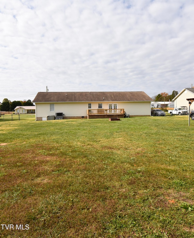 rear view of property with a yard and a deck