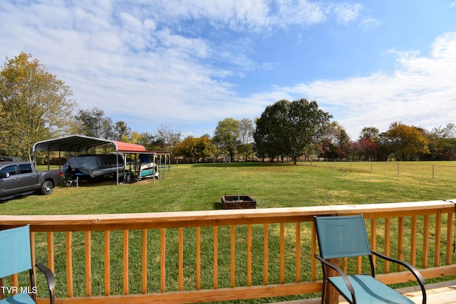 wooden terrace with a lawn and a carport