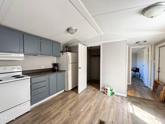 kitchen with lofted ceiling, extractor fan, wood-type flooring, gray cabinets, and white appliances