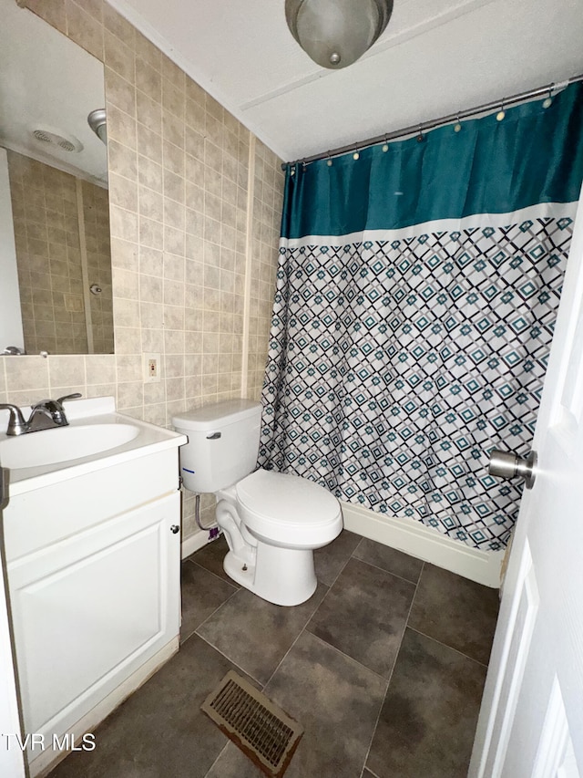 bathroom with tile walls, toilet, vanity, tile patterned floors, and a shower with shower curtain