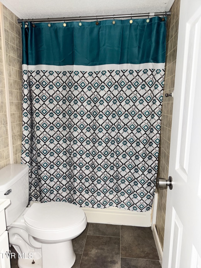 bathroom with toilet, tile patterned floors, a textured ceiling, and curtained shower