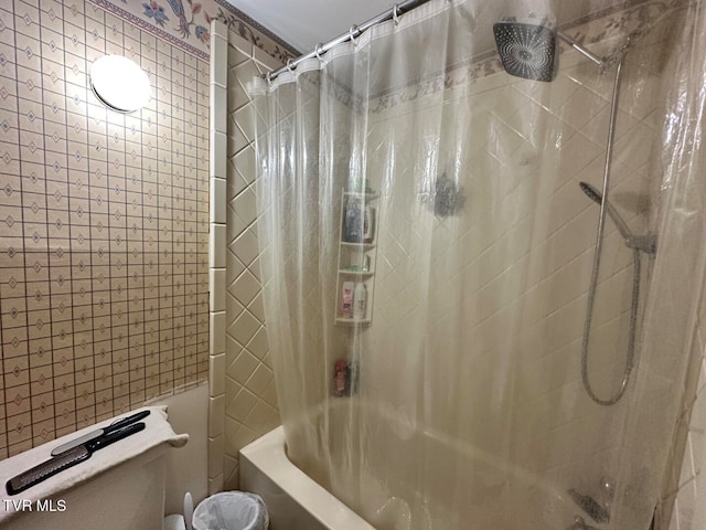 bathroom featuring toilet and shower / tub combo with curtain