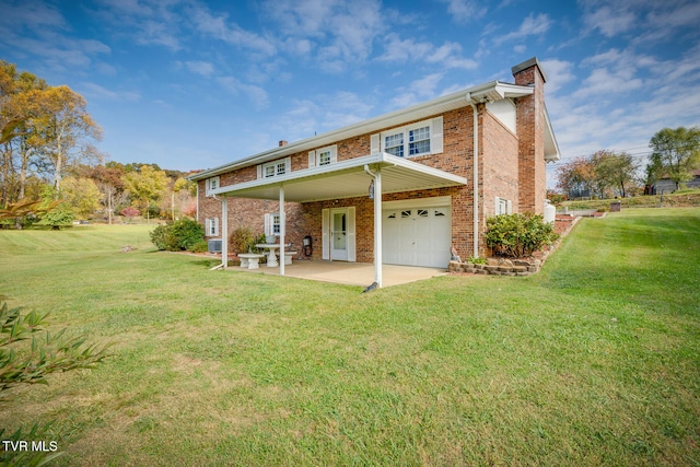 rear view of house featuring a garage, a yard, and a patio area