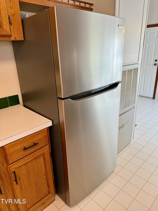 4527 Dorchester Rd, Norton, VA 24273 - kitchen with freestanding refrigerator, brown cabinets, light countertops, and light tile patterned flooring