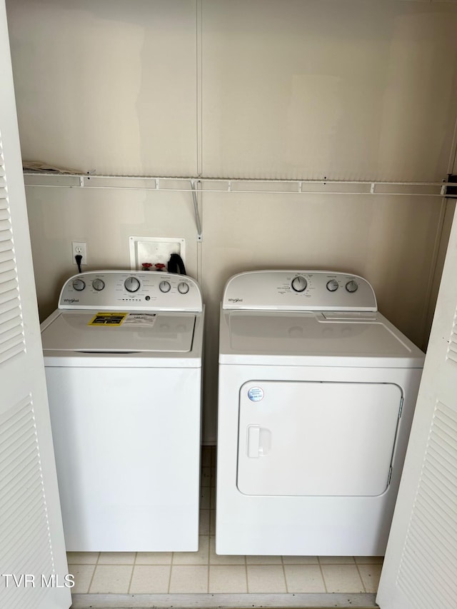 clothes washing area featuring independent washer and dryer and light tile patterned floors