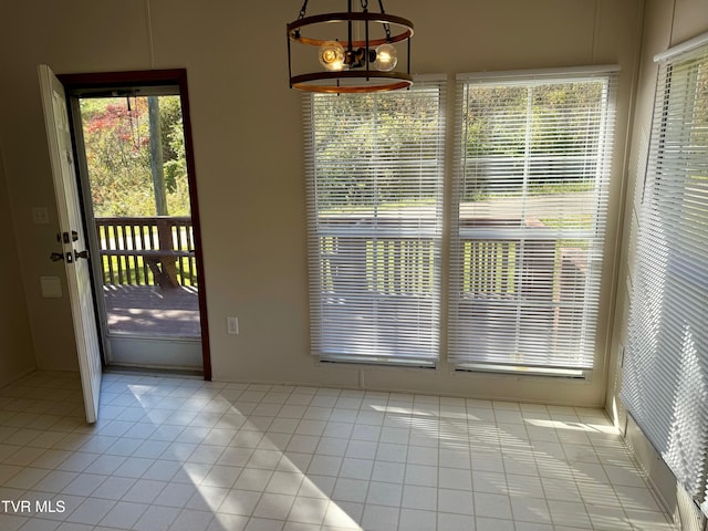 doorway to outside with a chandelier and light tile patterned floors