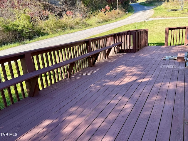 wooden deck featuring a lawn