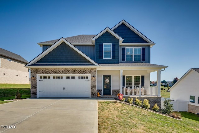 craftsman inspired home with a porch, a front lawn, and a garage