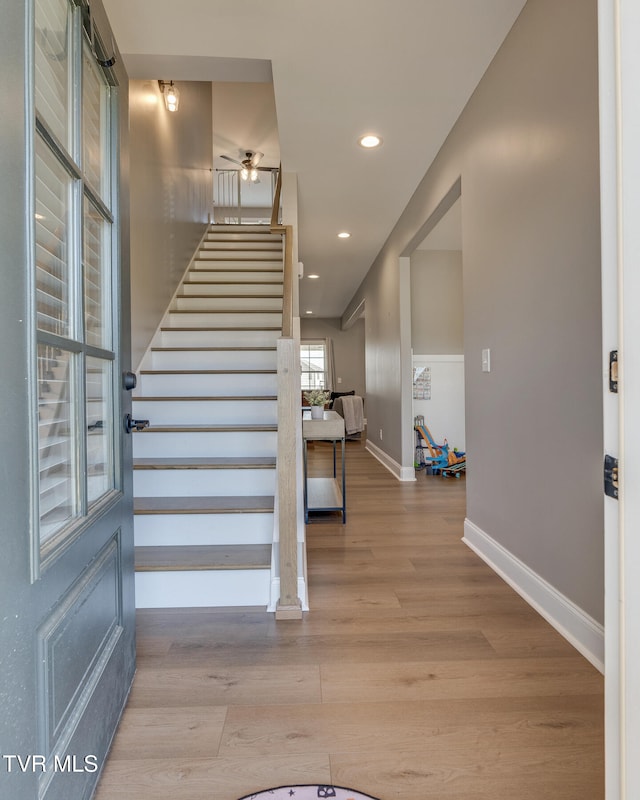 stairway with ceiling fan and hardwood / wood-style floors