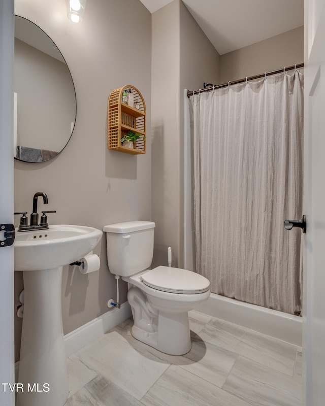 bathroom with toilet and curtained shower