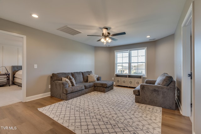 living room with ceiling fan and light wood-type flooring