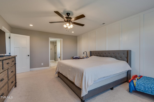 carpeted bedroom with ensuite bath and ceiling fan