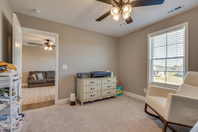 living area with ceiling fan, a healthy amount of sunlight, and light colored carpet