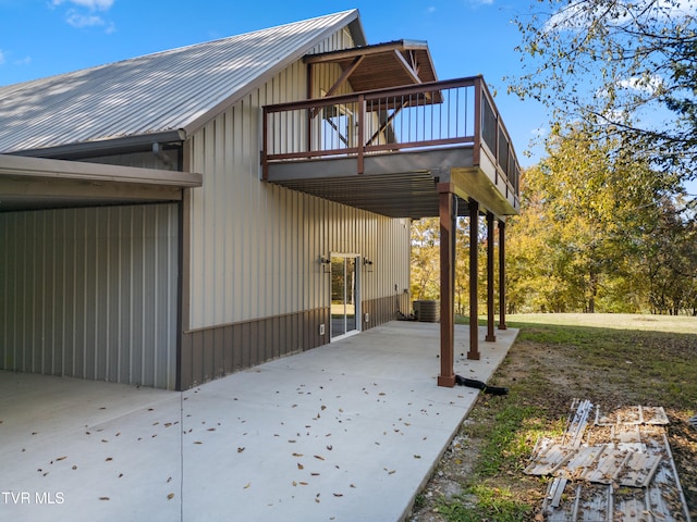 view of side of property featuring a patio area and a balcony