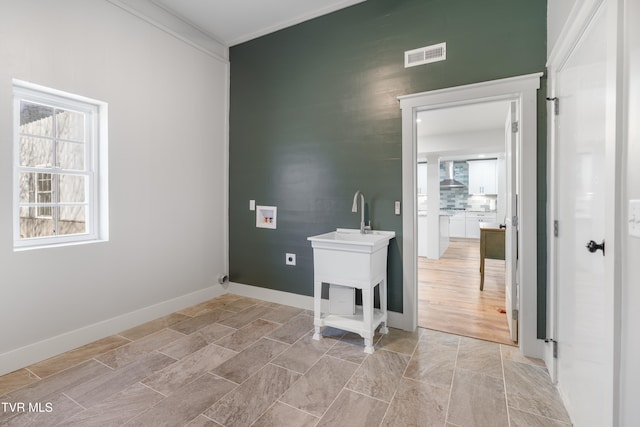 clothes washing area featuring hookup for a washing machine and light hardwood / wood-style floors