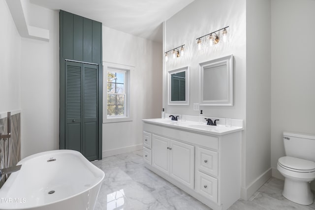 bathroom featuring vanity, toilet, and a tub