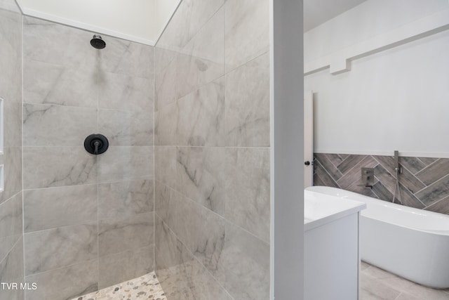 bathroom featuring vanity, independent shower and bath, and tile walls