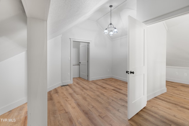 interior space with lofted ceiling, a textured ceiling, and wood-type flooring