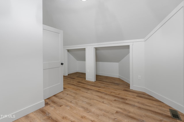 additional living space with lofted ceiling and light wood-type flooring