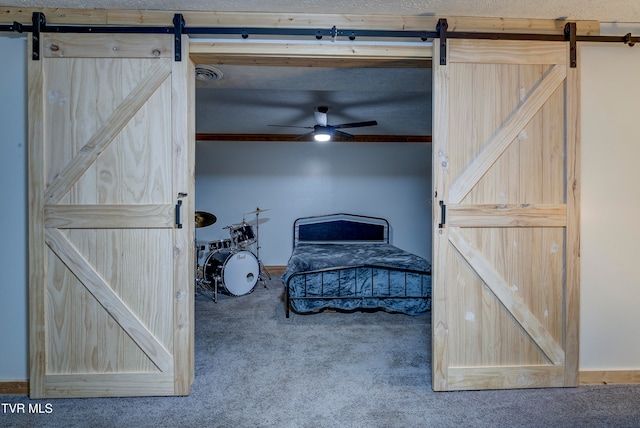 carpeted bedroom featuring a barn door