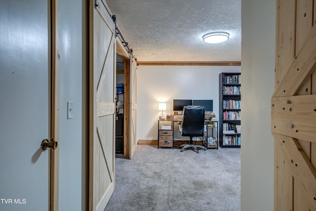 carpeted office featuring a barn door and a textured ceiling