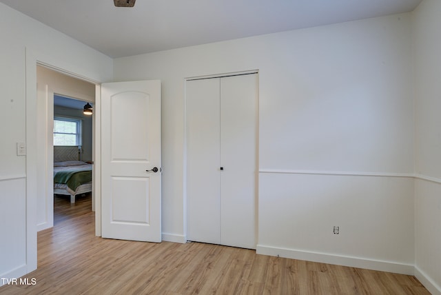 unfurnished bedroom featuring light hardwood / wood-style flooring and a closet