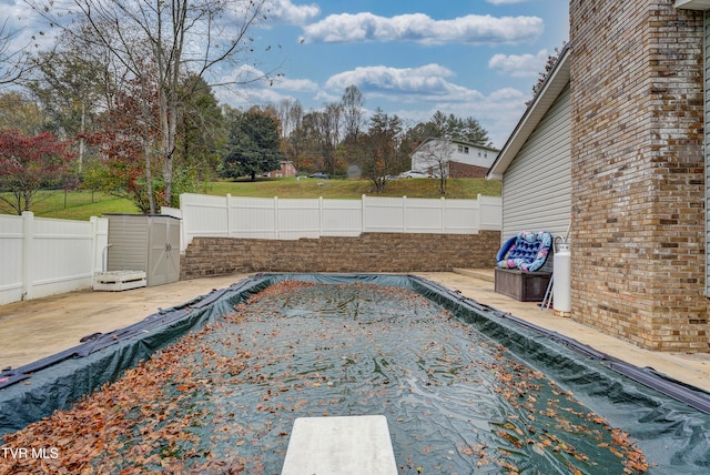 view of swimming pool featuring a diving board