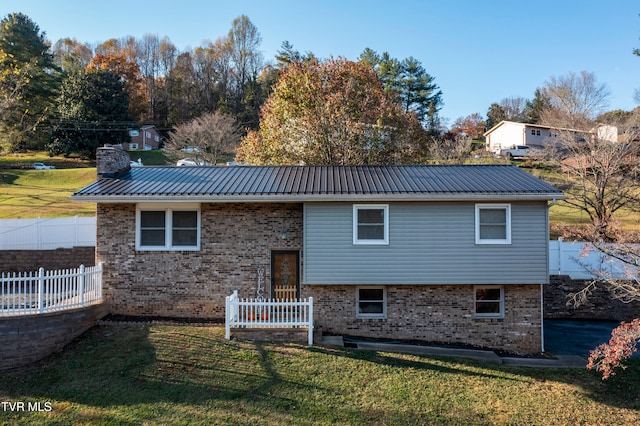 rear view of house featuring a yard