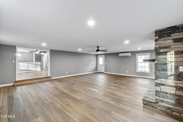 unfurnished living room with wood finished floors, a ceiling fan, and baseboards
