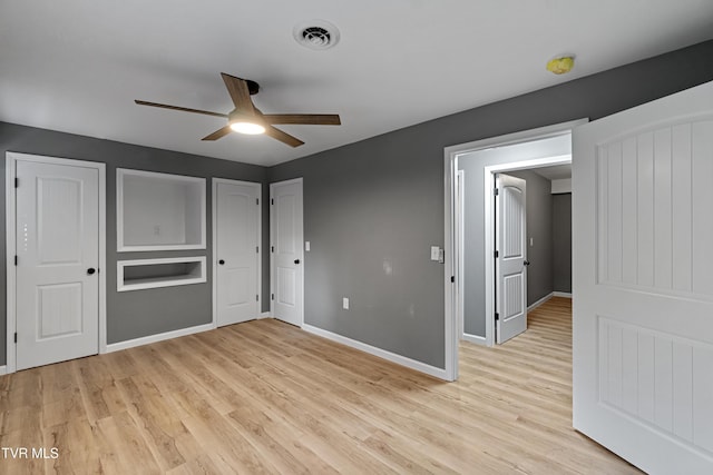 interior space with visible vents, ceiling fan, light wood-style flooring, and baseboards