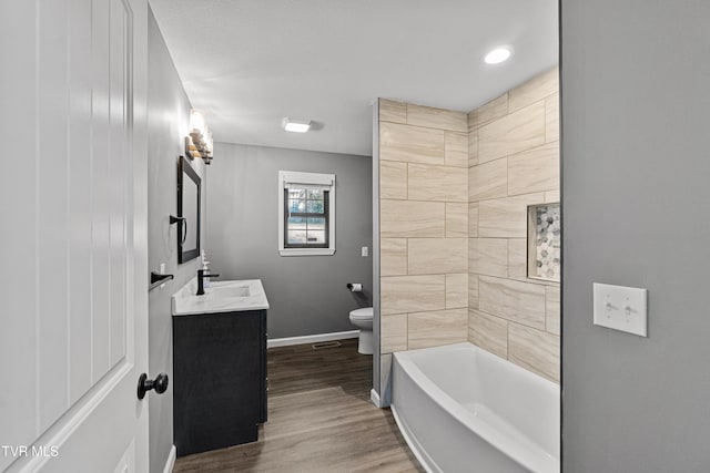full bath featuring baseboards, wood finished floors, toilet, and vanity