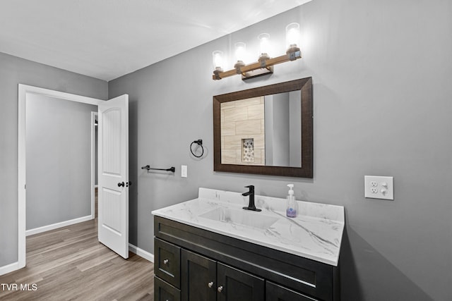 bathroom featuring wood finished floors, vanity, and baseboards