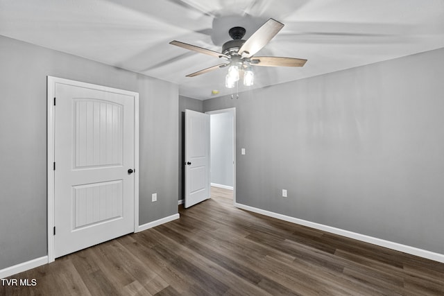 unfurnished bedroom featuring a ceiling fan, dark wood finished floors, and baseboards
