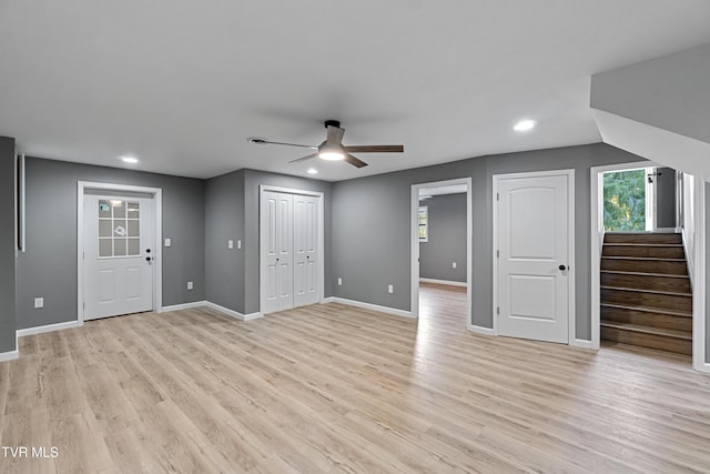 interior space featuring light wood finished floors, a ceiling fan, plenty of natural light, and baseboards