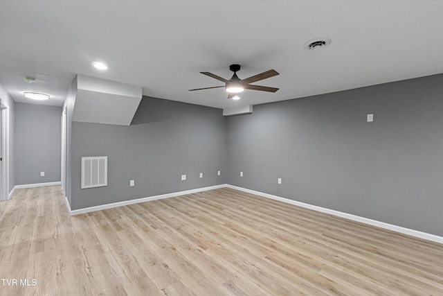 spare room with baseboards, visible vents, a ceiling fan, and light wood-style floors