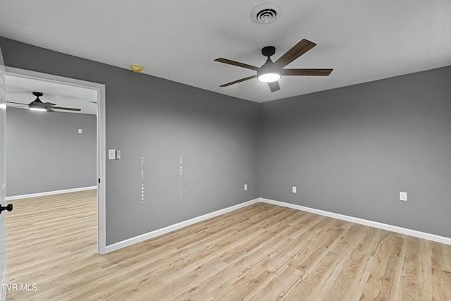 spare room with baseboards, visible vents, wood finished floors, and ceiling fan