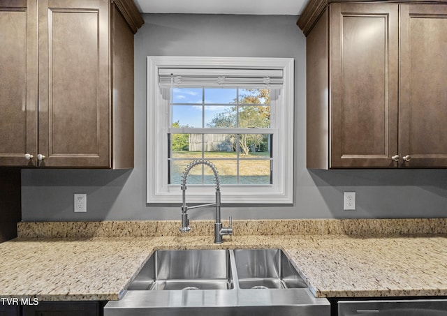 kitchen featuring dark brown cabinetry, dishwasher, and a sink