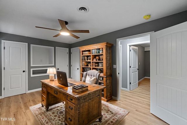 office space with ceiling fan, light wood-type flooring, visible vents, and baseboards