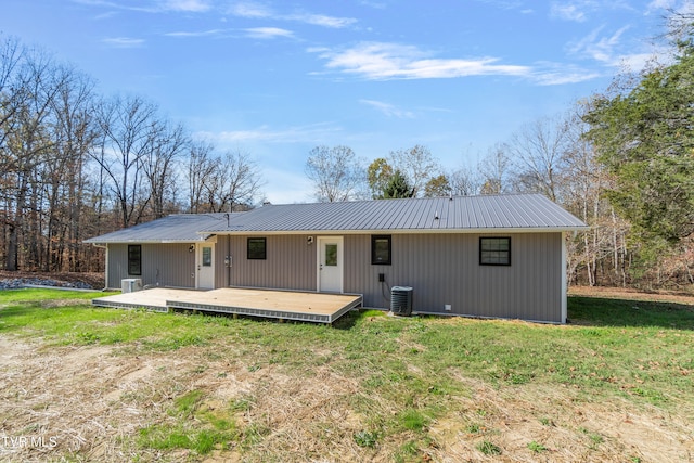 back of property with a yard, central air condition unit, and a wooden deck