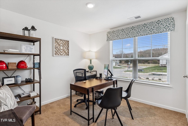 office area with light colored carpet, visible vents, and baseboards