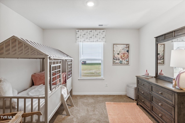 bedroom with light carpet, visible vents, and baseboards