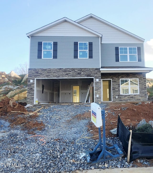 view of front of property with a garage and stone siding