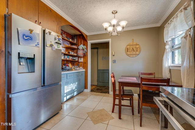 kitchen featuring ornamental molding, a notable chandelier, stainless steel fridge, and light tile patterned flooring