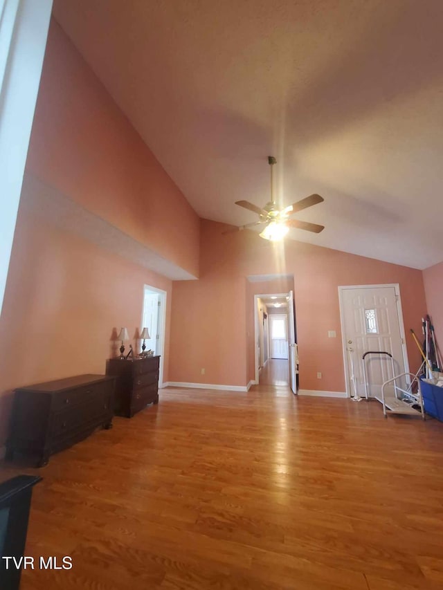 unfurnished living room featuring ceiling fan, lofted ceiling, and light wood-type flooring