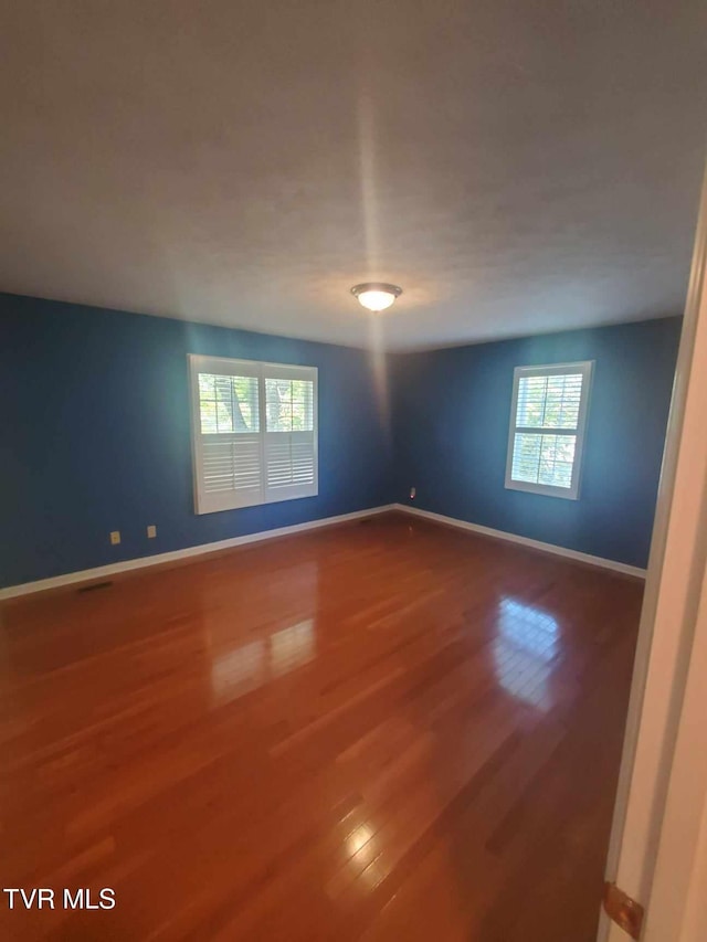 empty room with hardwood / wood-style flooring