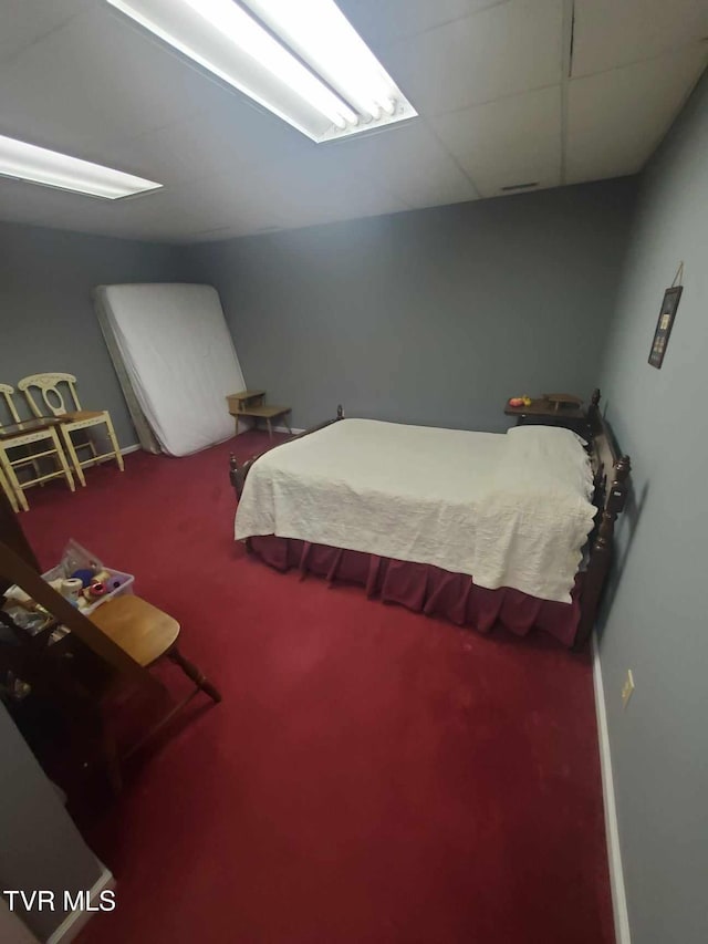 carpeted bedroom featuring a paneled ceiling