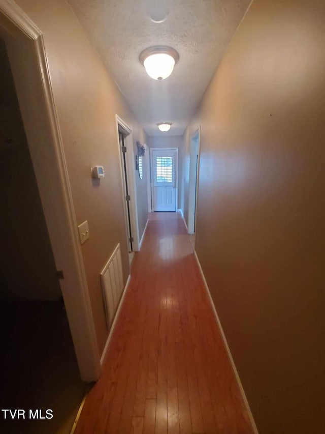 corridor with wood-type flooring