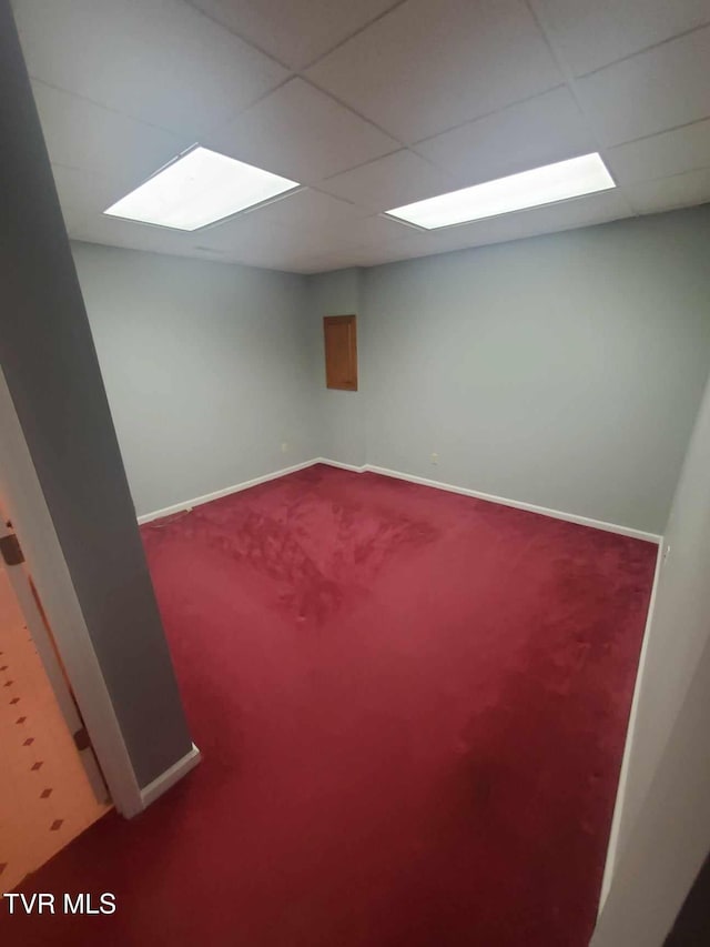 basement featuring a drop ceiling and carpet flooring