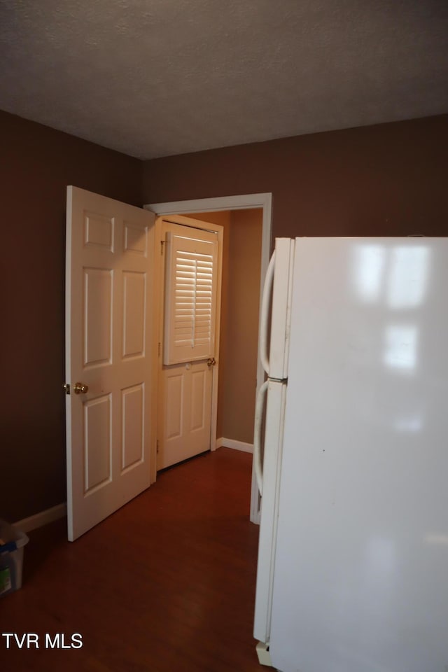 kitchen with hardwood / wood-style floors, a textured ceiling, and white refrigerator