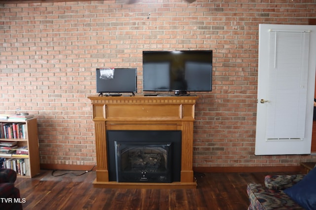 unfurnished living room with brick wall and dark wood-type flooring